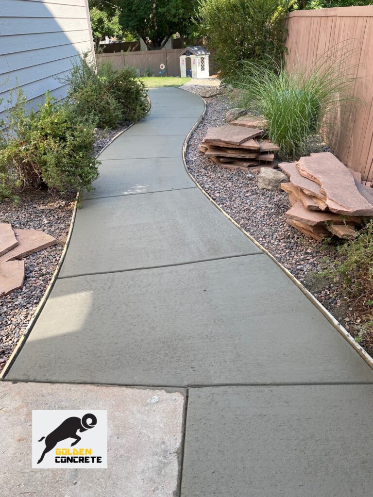 Curved concrete walkway along the side of a house