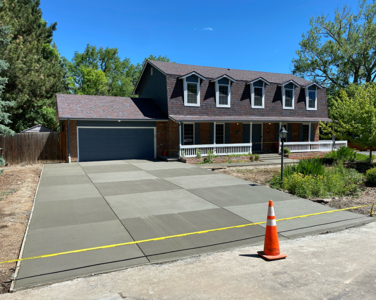 Freshly poured concrete driveway in front of a two-story home