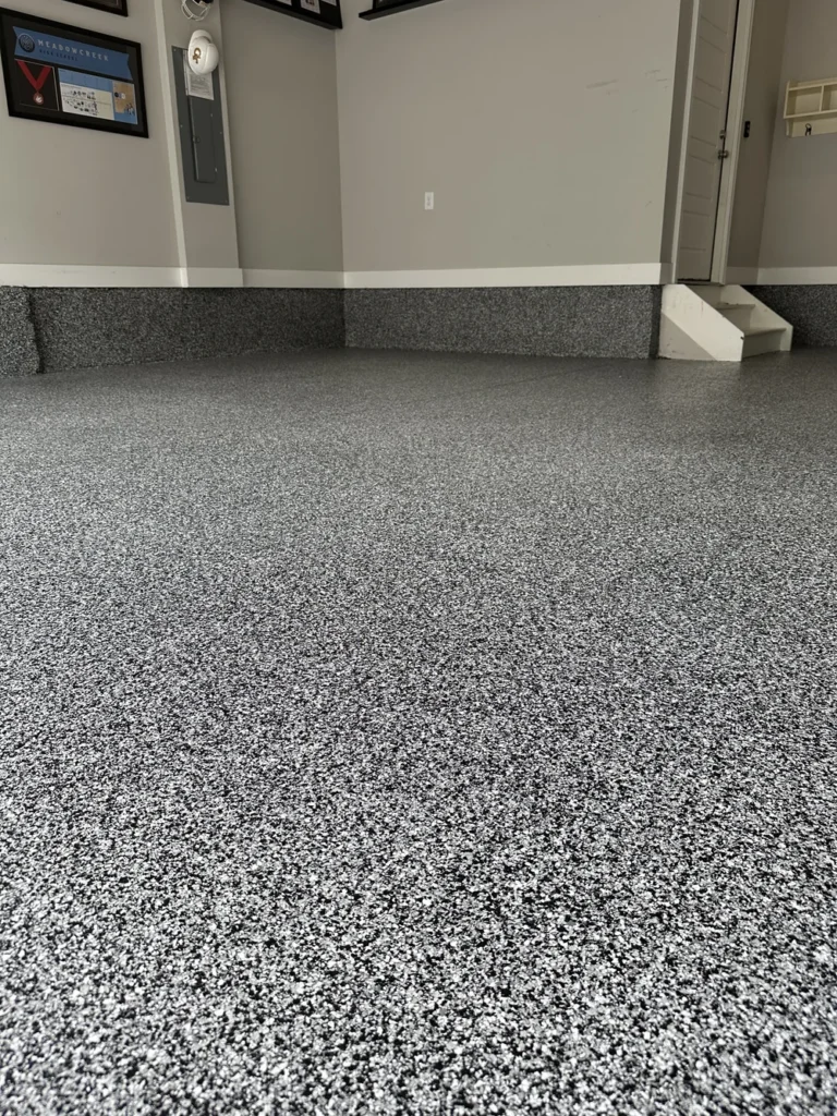 Gray flake epoxy garage floor with matching coated stem walls