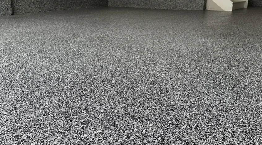 Gray flake epoxy garage floor with matching coated stem walls